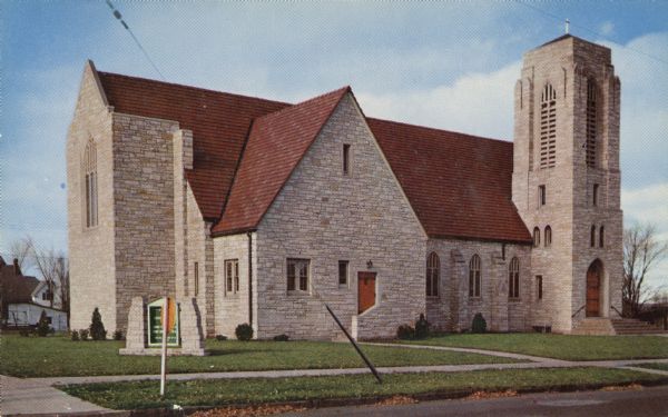 Color postcard of stone church, red roof, blue sky.